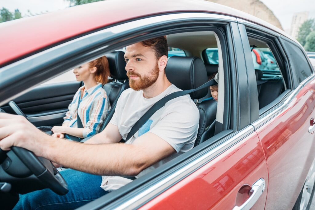young beautiful family riding on car together